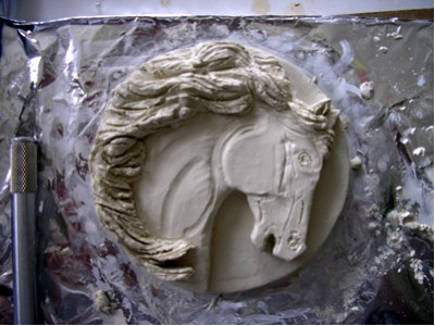 I was so engrossed with the mane I forgot to take pictures :-) Once the mane was on and carved, it was easier to add more features to the face as well by wetting and molding the clay.