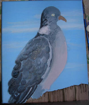 The pigeon is really taking shape. He's sitting on a fence.
